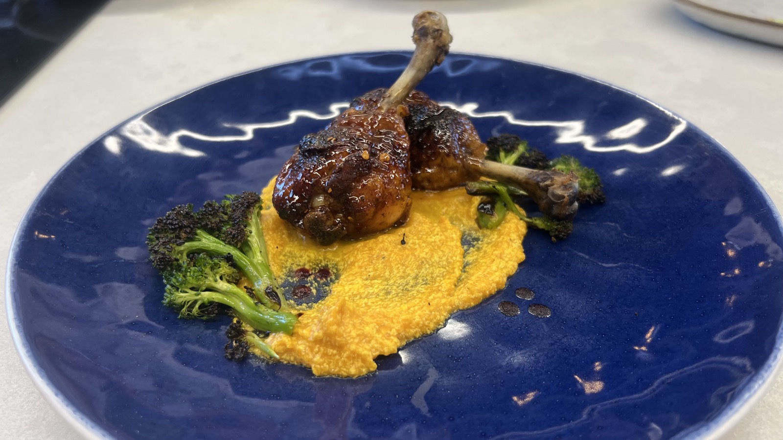 Confit duck leg on blue plate